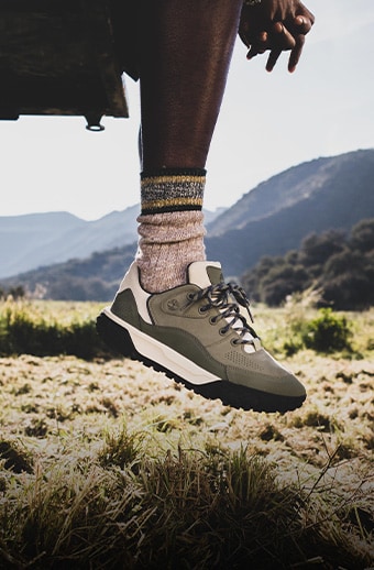 Knee down picture of a man wearing Timberland sneakers.