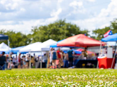 Image of an outdoor festival with colorful tents